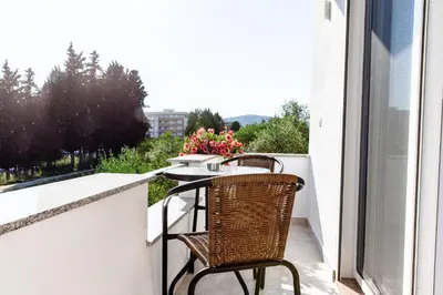 a balcony with two chairs and a table with flowers at Apartments Hoxha in Ulcinj
