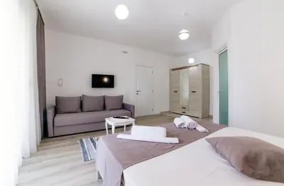 a bedroom with a large bed and a couch at Apartments Hoxha in Ulcinj