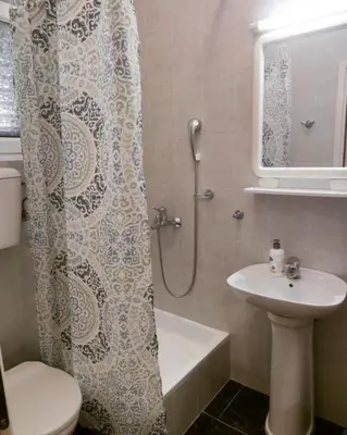 a bathroom with a shower curtain and a sink at Apartmani Soljaga in Petrovac na Moru