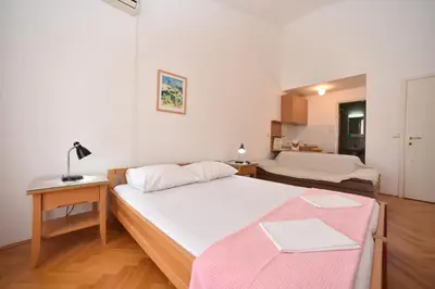 a bedroom with a bed and a table with a lamp at Apartmani Soljaga in Petrovac na Moru