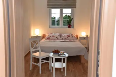 a small bedroom with a bed and a table at BIO VILLAS in Podgorica