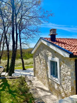 a stone house with a window and a red roof at BIO VILLAS in Podgorica