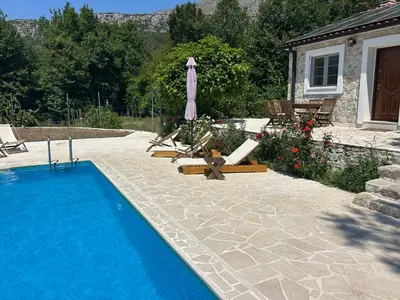 a swimming pool with lounge chairs and an umbrella at BIO VILLAS in Podgorica