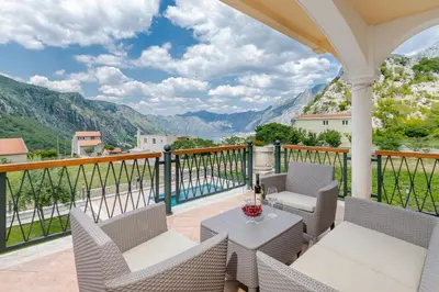 a patio with a table and chairs on a balcony at Sunset Rose in Kotor
