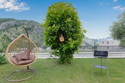 a rattan chair and a chair in a yard at Sunset Rose in Kotor