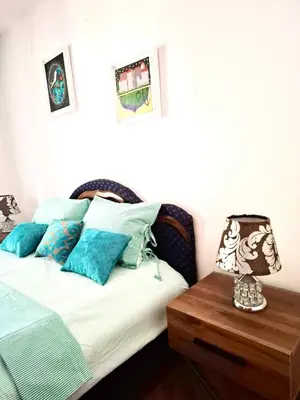 a bedroom with a bed and a table with a lamp at Sunset Rose in Kotor