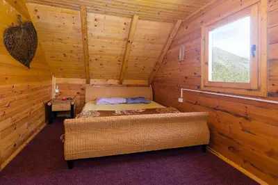 a bedroom with a bed in a log cabin at Lovcen mountain cottages in Vratnica