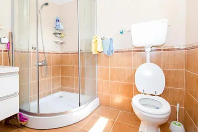 a bathroom with a shower and a toilet and a sink at Lovcen mountain cottages in Vratnica