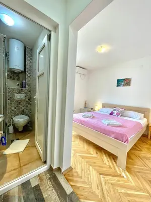 a bedroom with a large bed and a shower at Garden House Budva in Budva
