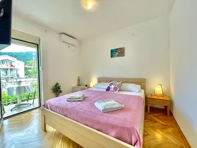 a bedroom with a large bed with a pink blanket at Garden House Budva in Budva