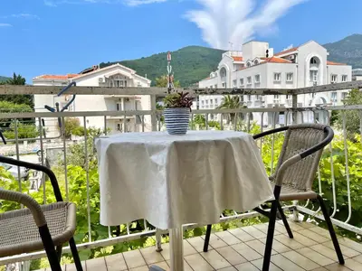 a table with a vase on it on a balcony at Garden House Budva in Budva