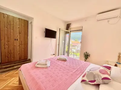 a bedroom with a pink bed and a window at Garden House Budva in Budva