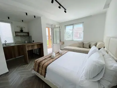 a bedroom with a large white bed and a couch at Guest House Koliqi - Hotel & Apartments in Ulcinj