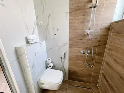 a bathroom with a toilet and a shower at Guest House Koliqi - Hotel & Apartments in Ulcinj