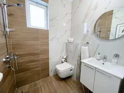 a bathroom with a toilet and a sink and a mirror at Guest House Koliqi - Hotel & Apartments in Ulcinj