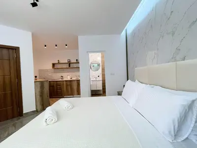 a bedroom with a large white bed with white pillows at Guest House Koliqi - Hotel & Apartments in Ulcinj