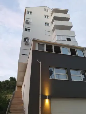 a tall white building with a staircase in front of it at Sunny Hill Suite Ljubovic in Podgorica