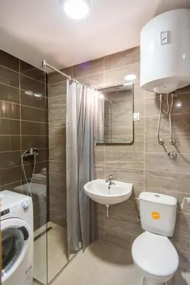 a bathroom with a toilet and a sink and a shower at Sunny Hill Suite Ljubovic in Podgorica