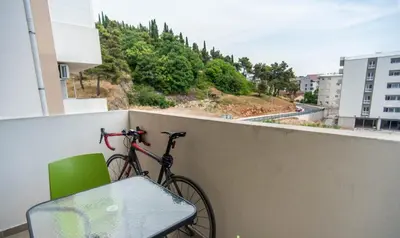 a bike is parked on a balcony with a table at Sunny Hill Suite Ljubovic in Podgorica