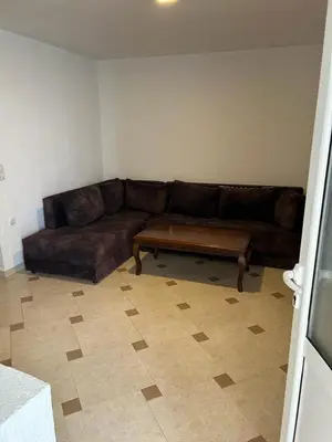 a living room with a brown couch and a coffee table at Apartments Doda in Ulcinj