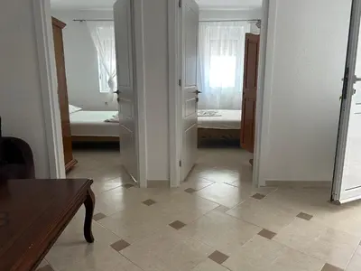 a room with a kitchen and a room with two beds at Apartments Doda in Ulcinj