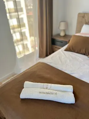 a pair of towels sitting on top of a bed at Luxury Apartment Sea View Soho City 5th floor in Bar