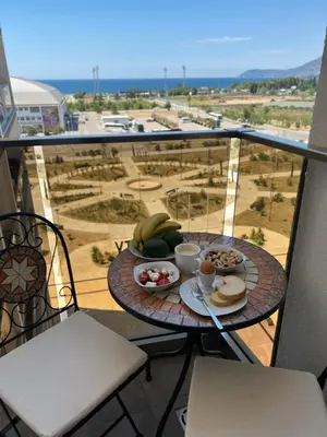 a table with a plate of food on a balcony at Luxury Apartment Sea View Soho City 5th floor in Bar