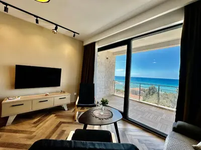 a living room with a television and a view of the ocean at White Star Apartments in Utjeha