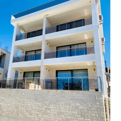 a white building with a balcony with a table on it at White Star Apartments in Utjeha