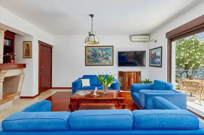 a living room with blue couches and a table at Apartment Aura with Sea View in Kotor