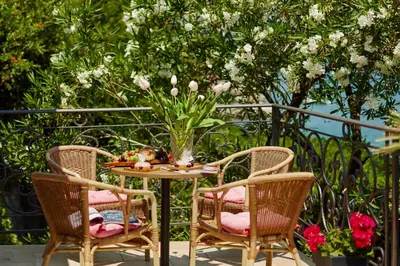 a table with two chairs and a vase with flowers at Apartment Aura with Sea View in Kotor