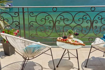 a table with two chairs and two glasses of wine at Apartment Aura with Sea View in Kotor