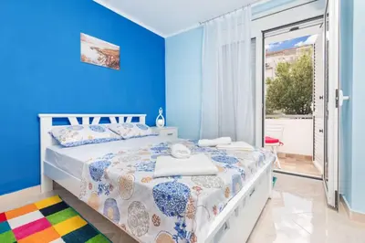 a blue bedroom with a bed and a sliding glass door at Apartment Milos in Kotor