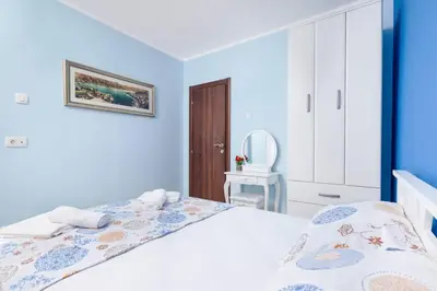 a blue bedroom with a bed and a chair at Apartment Milos in Kotor