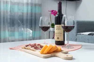 a table with two glasses of wine and cheese at Apartment Milos in Kotor