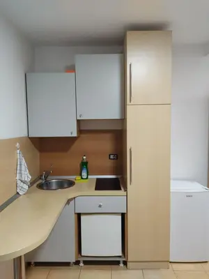a kitchen with white cabinets and a sink and a refrigerator at Apartments Mare Budva in Budva