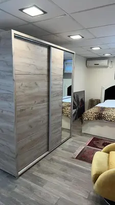 a bedroom with a large wooden closet with a mirror at Ribnica in Podgorica