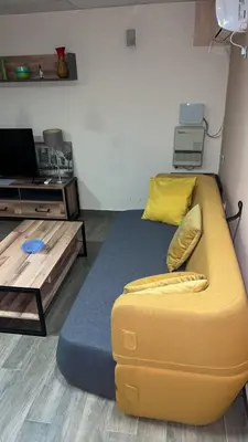a yellow couch in a living room with a table at Ribnica in Podgorica