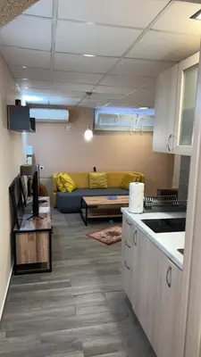 a kitchen and a living room with a couch at Ribnica in Podgorica