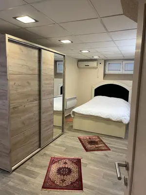 a small room with a bed and a bedroom with rugs at Ribnica in Podgorica