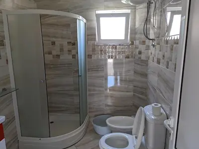 a bathroom with a shower and two toilets in it at Apartments BEA in Ulcinj