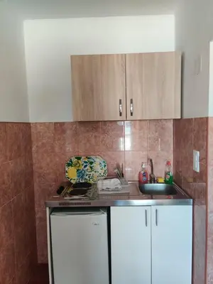 a kitchen with a white refrigerator and a sink at Apartments BEA in Ulcinj