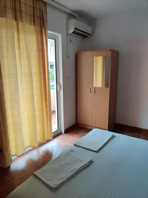 a bedroom with a bed and a cabinet and a window at Apartments BEA in Ulcinj