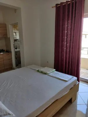 a bed in a room with a red curtain at Apartments BEA in Ulcinj