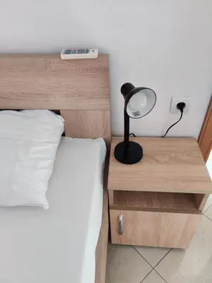 a bed with a desk with a lamp on it at Apartments BEA in Ulcinj