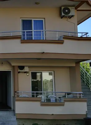 a building with a balcony with two chairs on it at Apartments BEA in Ulcinj