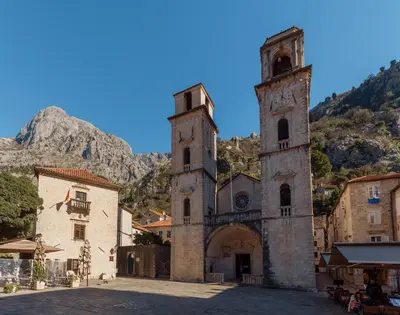 an old building with a clock tower in a town at Old Town St Tryphon Apartment in Kotor