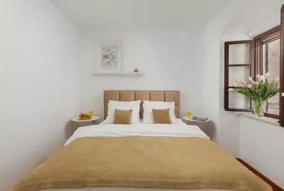 a bedroom with a large bed and a window at Old Town St Tryphon Apartment in Kotor
