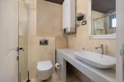 a bathroom with a sink and a toilet and a mirror at Old Town St Tryphon Apartment in Kotor