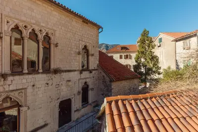 an old brick building with windows and a roof at Old Town St Tryphon Apartment in Kotor